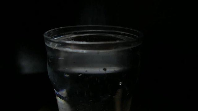 Sparkling water glass melting ice cubes. 4K UHD