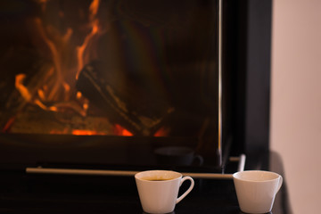 two mugs in front of fireplace