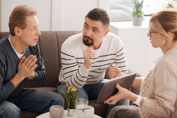 Unhappy worried man looking at the psychologist