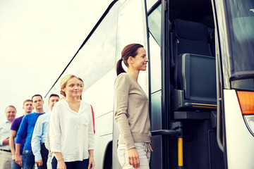 group of happy passengers boarding travel bus