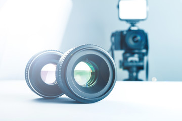 Two lenses on a white table against the background of the camera to light and softbox.