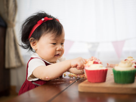baby girl eating cup cake