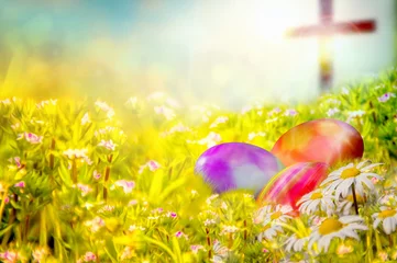 Gordijnen Easter background with colorful painted Easter eggs in the grass, with spring flowers and a cross in the background. Easter resurrection religious background with copy space for text. © t0m15