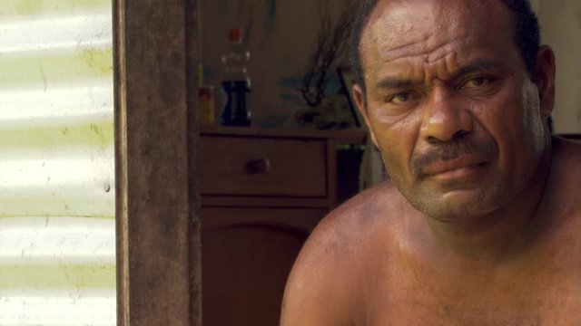 Close-up face of shirtless Fijian man in doorway