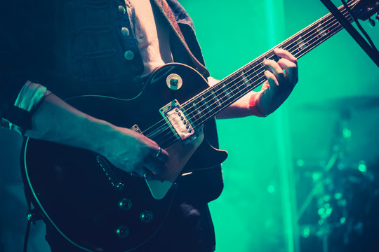 Electric guitar player on stage in green light