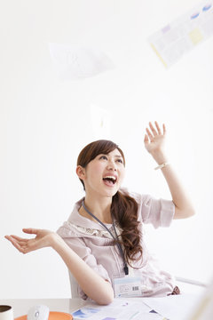 Businesswoman throwing papers