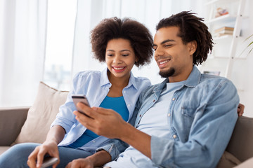 Fototapeta premium happy couple with smartphones at home