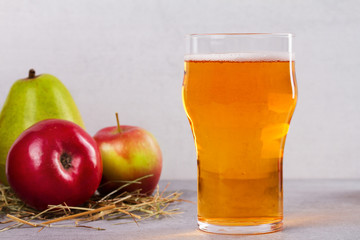 Glass and bottles of apple and pear cider with fruits