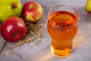 Glass and bottles of apple and pear cider with fruits