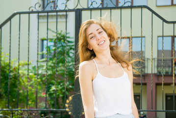 Street fashion concept. Young beautiful model in the city. Outdoor fashion closeup portrait of young pretty woman in sunny day on street 
