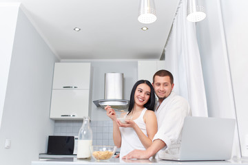 Couple having breakfast at kitchen and watching news.