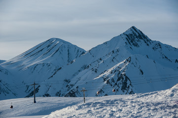 Fototapeta na wymiar Snowy winter mountains in sun day. Caucasus Mountains, Georgia, from ski resort Gudauri