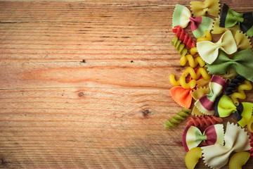 different kind of pasta on rustic wooden table .Italian food background.top view