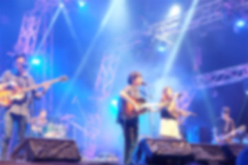 Fototapeta na wymiar Blurred background : Bokeh lighting in outdoor concert with musicians on the stage