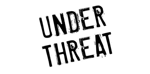 Under Threat rubber stamp. Grunge design with dust scratches. Effects can be easily removed for a clean, crisp look. Color is easily changed.