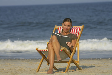 Woman sitting on a beach chair while reading