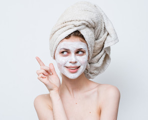 Woman with cream on face and towel on head