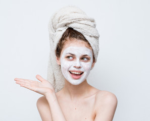 Woman with cream on face and towel on head
