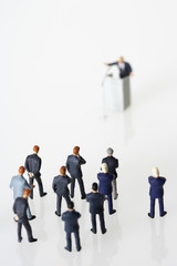 Businessmen figurines listening a speech