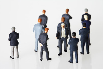 Businessmen figurines, one looking in opposite direction