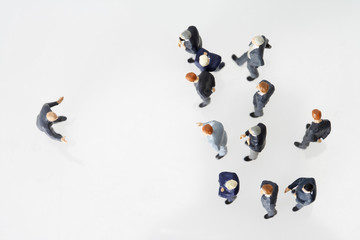 Group of businessmen figurines and one businessman figurine standing vis-√†-vis