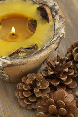 Perfumed candle and pine cones