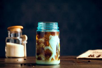 Iced Organic Vegan Coffee With Cream Served In Blue Mason Jar On Table With Natural Sugar. Copy Space With Selective Focus.
