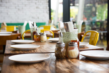 Fototapeta na wymiar setup wooden table, plates, utensils, and condiments