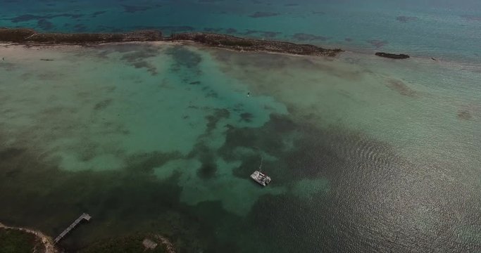 Aerial View of a yacht on green reef ocean, Bahamas