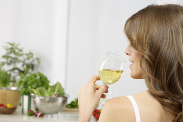 Mid adult woman drinking a glass of white wine