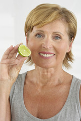 Senior woman holding a slice of lime