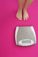 Woman standing next to a weighing scale