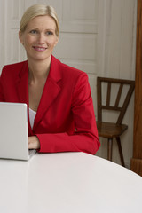 Blond woman sitting behind a laptop, close-up