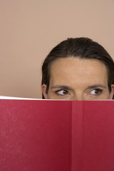 Woman looking over a red book