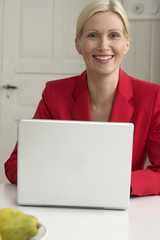 Blond woman sitting behind a laptop, close-up