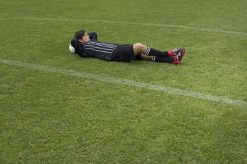 Relaxed referee lying on soccer field