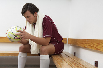 Reflective kicker holding ball sitting in dressing room © STOCK4B 