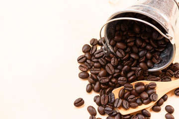 Coffee beans, wooden scoop and tank on wooden background.