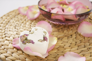 A heart-shaped piece of soap on rose petals