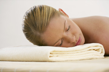 Obraz na płótnie Canvas Young woman lying on a towel