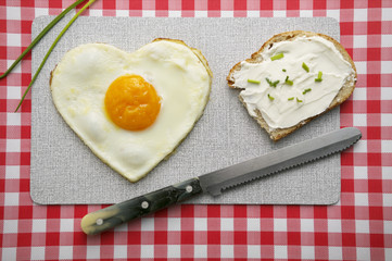 Heart-shaped fried egg and a bread with cream cheese