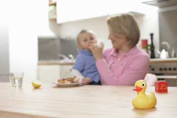 Obraz na płótnie Canvas Mother feeding son, rubber duck in foreground