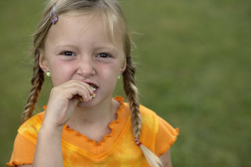 Little girl with her hand on her mouth, selective focus