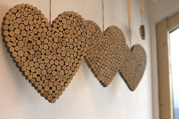 Four hearts made of cork hanging from the ceiling, close-up, selective focus