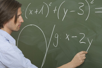 Man is writing prims on a board