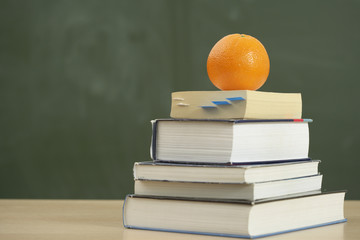 A pack with books - an orange on top