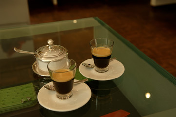 Two coffee glasses on a glasstable