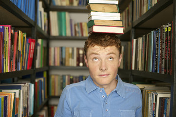 Student balancing a stack of books on head
