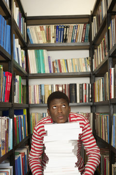 Student behind a stack of books