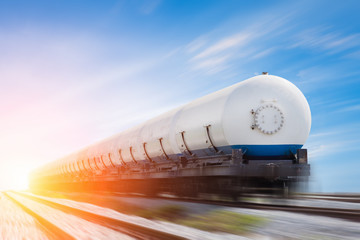 Naklejka premium Zbiorniki z gazem transportowane koleją o zachodzie słońca